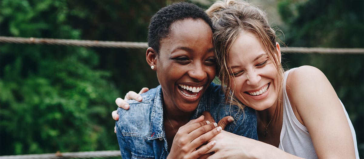 Two women laughing and hugging together